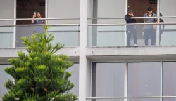 TOPSHOT - Members of the Iranian women?s football team are seen on their respective room balconies at the Royal Pines Resort on the Gold Coast on March 9, 2026. Australia must protect the visiting Iranian women's football team, the son of the nation's late shah urged March 9, warning their refusal to sing the national anthem before a match could have "dire consequences". (Photo by Patrick HAMILTON/AFP)