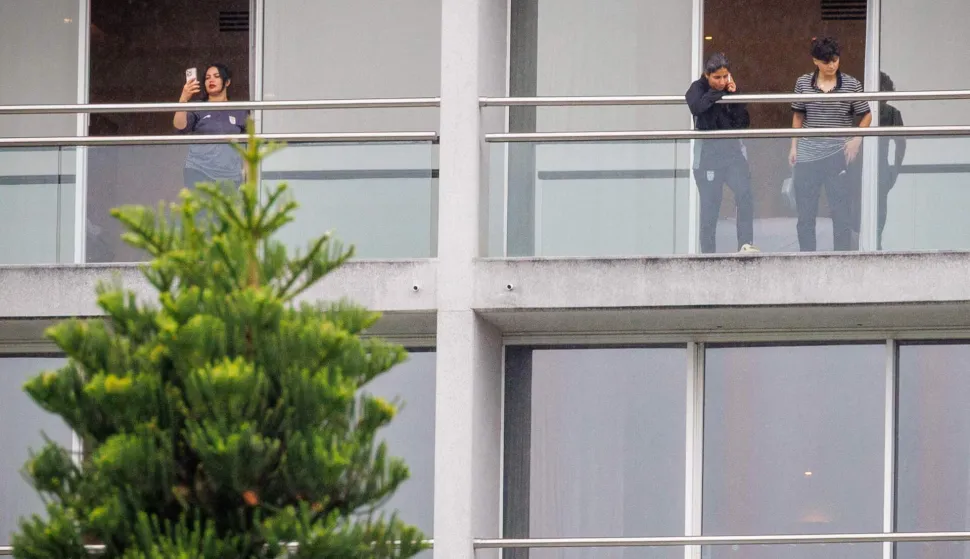 TOPSHOT - Members of the Iranian women?s football team are seen on their respective room balconies at the Royal Pines Resort on the Gold Coast on March 9, 2026. Australia must protect the visiting Iranian women's football team, the son of the nation's late shah urged March 9, warning their refusal to sing the national anthem before a match could have "dire consequences". (Photo by Patrick HAMILTON/AFP)