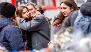 Mourners gather near the site of a fire that ripped through a bar during New Year's Eve celebrations in the Alpine ski resort town of Crans-Montanal killing around 40 people and injuring more than 100 others, in Crans-Montana on January 2, 2026. Investigators raced on January 2, 2026 to identify the victims of a fire that ripped through a bar in the Swiss Alps town of Crans-Montana, turning a New Year's celebration into one of the country's worst tragedies. Frederic Gisler, police commander in the Wallis canton in southwestern Switzerland, told reporters that authorities had counted "around 40 people who have died and around 115 injured, most of them seriously". (Photo by MAXIME SCHMID/AFP)