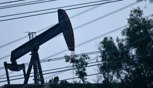 A pumpjack operates in the Montebello Oil Field behind a row of power lines on March 4, 2026 in Montebello, California. US and European stock markets advanced March 4 as oil prices steadied, after Asian bourses suffered deep losses amid inflation worries sparked by the US-Iran war. Markets have been roiled much of the week as the conflict between the US and Iran effectively closed shipping through the Strait of Hormuz, where a fifth of the world's crude oil travels as well as considerable liquefied natural gas (LNG) supplies travel through. (Photo by Frederic J. BROWN/AFP)