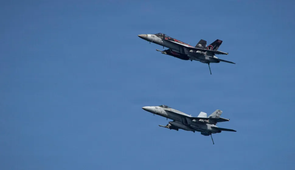 This US Navy handout photo released by US Central Command public affairs on March 12, 2026, shows two F/A-18E Super Hornets, attached to Strike Fighter Squadron (VFA) 14, as they fly over Nimitz-class aircraft carrier USS Abraham Lincoln (CVN 72) in support of Operation Epic Fury, on March 7, 2026. The United States and Israel launched a wave of strikes against targets in Iran on February 28, sparking swift retaliation by the Islamic republic which responded with missile attacks across the region. (Photo by US NAVY/AFP)/RESTRICTED TO EDITORIAL USE - MANDATORY CREDIT "AFP PHOTO/US NAVY and US CENTRAL COMMAND/HANDOUT" - HANDOUT - NO MARKETING NO ADVERTISING CAMPAIGNS - DISTRIBUTED AS A SERVICE TO CLIENTS