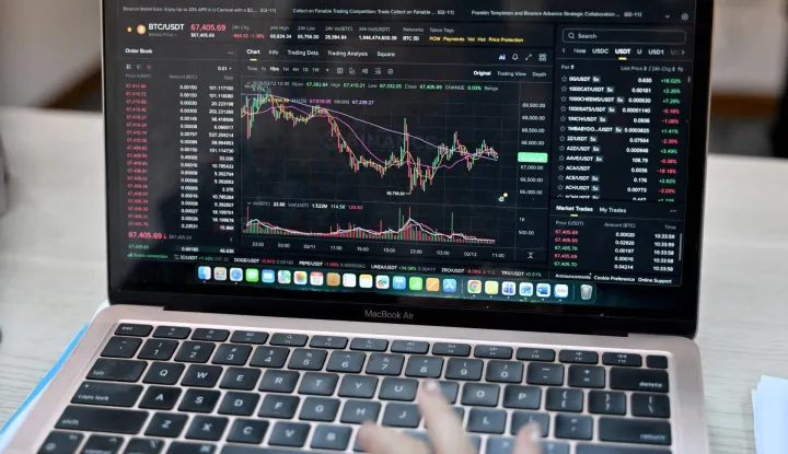 This photo taken on February 12, 2026 shows a Vietnamese cryptocurrency investor looking at the latest Bitcoin values on a laptop in Hanoi. As a first-year computer science student in Hanoi, Hoang Le started trading crypto from his university dorm room, egged on by his gamer friends who were making a killing, and at one point his digital holdings swelled to 0,000 -- around 50 times the average annual income in Vietnam. But they crashed to zero when the bottom fell out of bitcoin and other cryptocurrencies in recent months. (Photo by Nhac NGUYEN/AFP)/To go with 'VIETNAM-ECONOMY-CRYPTO,FOCUS' by Lam NGUYEN