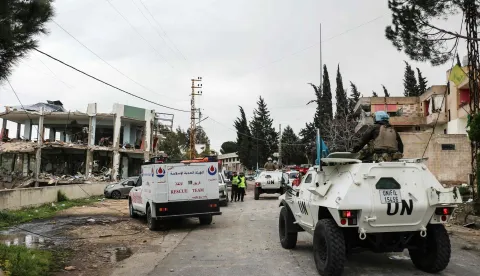 United Nations peacekeepers with the UN Interim Force in Lebanon (UNIFIL) drive past a destroyed healthcare centre building in the aftermath of an Israeli strike in the southern Lebanese town of Burj Qalawiya on March 14, 2026. An overnight Israeli strike killed a dozen medical staff at a clinic in south Lebanon, health authorities said earlier on March 14, after the Iran-backed Hezbollah's leader said his group was ready for a long confrontation with Israel. Lebanon was drawn into the Middle East war last week when the militant group attacked Israel in response to the killing of the Iranian supreme leader in US-Israeli strikes. (Photo by Kawnat HAJU/AFP)
