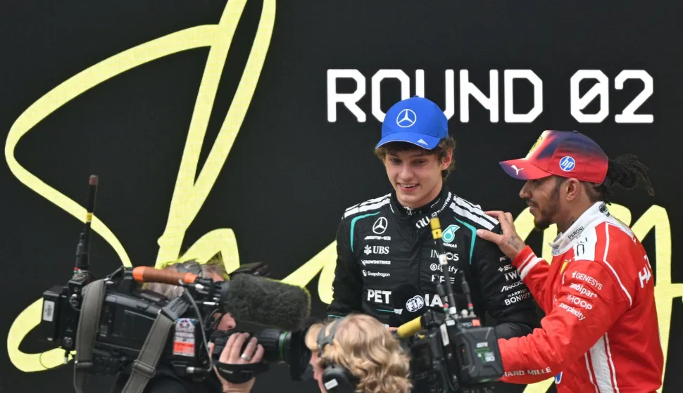 Winner Mercedes' Italian driver Kimi Antonelli (2nd R) and third-placed Ferrari's British driver Lewis Hamilton (R) speak after the Formula One Chinese Grand Prix at the Shanghai International Circuit in Shanghai on March 15, 2026. (Photo by HECTOR RETAMAL/AFP)
