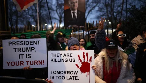 Anti-Iranian regime protesters wave Iranian flags during a gathering outside the Iranian Embassy, central London, on January 12, 2026. (Photo by Henry NICHOLLS/AFP)