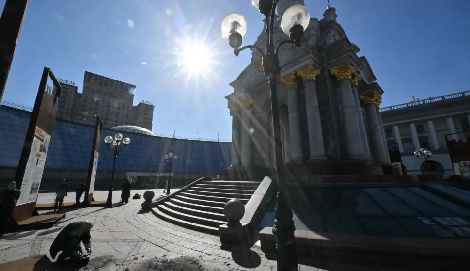 Journalists work at the site where debris from downed Russian drones crashed following a drone and missile attack, on Independence Square in Kyiv on March 16, 2026 amid the Russian invasion of Ukraine. (Photo by Sergei SUPINSKY/AFP)