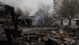 A man looks through debris at the site of a recent Russian air attack in front of a damaged residential apartment building in Zaporizhzhia on March 18, 2026, amid the Russian invasion of Ukraine. (Photo by Roman PILIPEY/AFP)