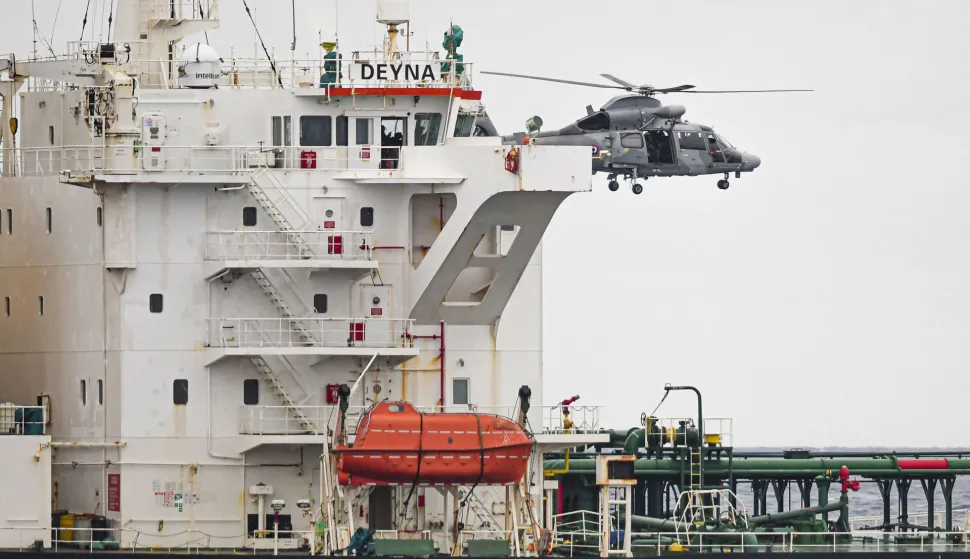 This handout photo taken and released on March 20, 2026, by the Etat Major des Armees (The French Defense Staff) shows a helicopter of the French Navy hovering over the Mozambican-flagged oil tanker Deyna during an interception operation in the western Mediterranean Sea. The French Navy intercepted an oil tanker sailing from Russia in the Mediterranean on March 20, 2026, maritime authorities said. The Mozambican-flagged Deyna, which sailed from Murmansk in northwestern Russia, was inspected over the regularity of its flag and will be escorted to an anchorage for further checks, the maritime prefecture added. (Photo by Etat Major des Arm?es/AFP)/RESTRICTED TO EDITORIAL USE - MANDATORY CREDIT "AFP PHOTO/ETAT MAJOR DES ARMEES" - HANDOUT - NO MARKETING NO ADVERTISING CAMPAIGNS - DISTRIBUTED AS A SERVICE TO CLIENTS