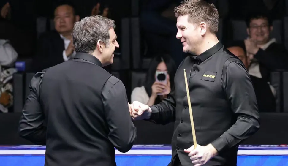 Britain's Ronnie O'Sullivan (L) is congratulated by Ryan Day of Wales after O?Sullivan made professional snooker history with the highest ever break of 153 during their match at the Snooker World Open in Yushan, in China?s Jiangxi province on March 20, 2026. (Photo by CN-STR/AFP)/China OUT