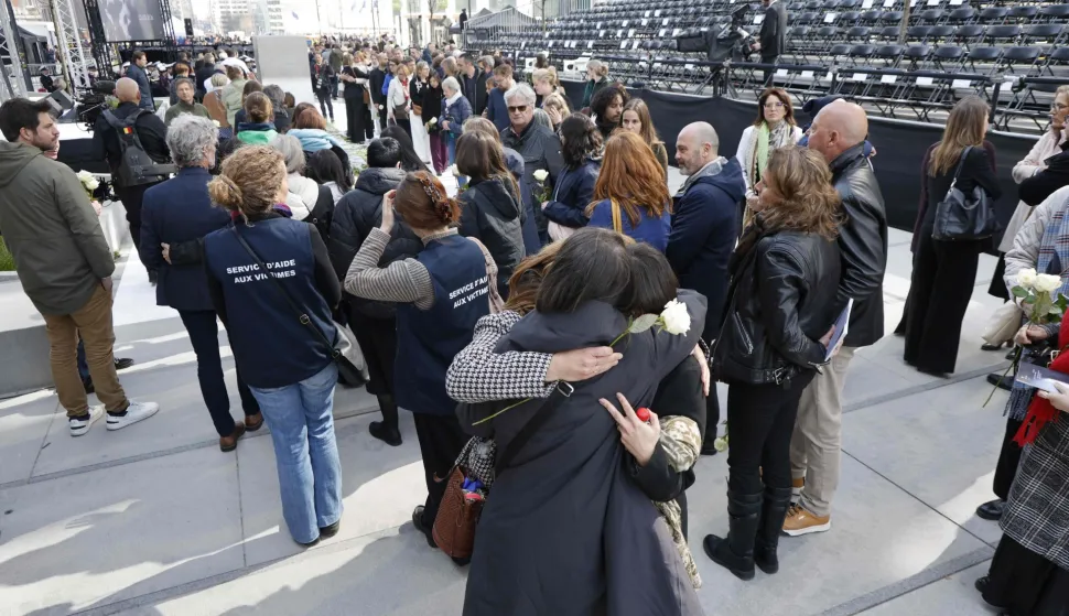Attendees embrace during a commemoration ceremony for the March 2016 terror attacks at the memorial monument on Rue de la Loi (Wetstraat) in Brussels on March 22, 2026. Belgium is marking the tenth anniversary of the 2016 jihadist bombings in Brussels, a trauma that still scars the country and that authorities say sharpened focus on intelligence and counterterrorism. (Photo by NICOLAS MAETERLINCK/Belga/AFP)/Belgium OUT