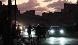 People transit on a street without power during a nation wide blackout in Havana on March 21, 2026. A power outage struck the entire island of Cuba on March 21, 2026, the energy ministry said, in the second nationwide blackout in less than a week as its grid struggles under a US oil blockade. (Photo by Yamil LAGE/AFP)