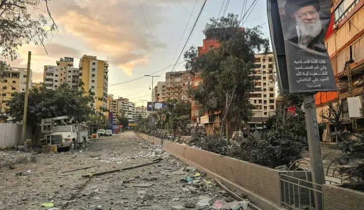 A photograph shows a portrait of Iran?s slain supreme leader Ayatollah Ali Khamenei along a street covered with debris following an Israeli airstrike in Beirut?s southern suburbs on March 28, 2026. Israel's military renewed its attacks on Beirut's southern suburbs on March 27, saying it was targeting Hezbollah infrastructure, as the Iran-backed group said the foes had clashed directly in the country's south. (Photo by AFP)/