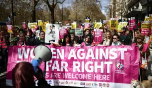 Protesters holding placards and waving flags take part in a march against the far right, organised by the Together Alliance, in central London on March 28, 2026. (Photo by Henry NICHOLLS/AFP)