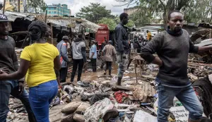 TOPSHOT - People walk around damaged property looking for salvageables in downtown Nairobi following a night of heavy rainfall that resulting in heavy flooding around Nairobi on March 07, 2026. (Photo by Tony KARUMBA/AFP)
