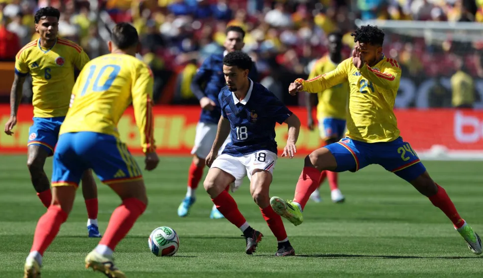 France's midfielder #18 Warren Zaire-Emery (C) controls the ball challenged Colombia's forward #24 Luis Suarez and Colombia's midfielder #10 James Rodriguez during a friendly football match between Colombia and France at Northwest Stadium in Landover, Maryland, on March 29, 2026. (Photo by FRANCK FIFE/AFP)