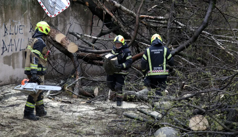 Zagreb, 27.03.2026 - Nevrijeme u Zagrebu. Jak vjetar ru&scaron;io je stabla i lomio grane, pri čemu su na pojedinim mjestima o&scaron;tećeni i automobili. Na fotografiji vatrogasci uklanjaju sru&scaron;eno stablo ispred ulaza u garažu u ulici Ružmarinka u Maksimiru.foto HINA/ Denis CERIĆ /dc