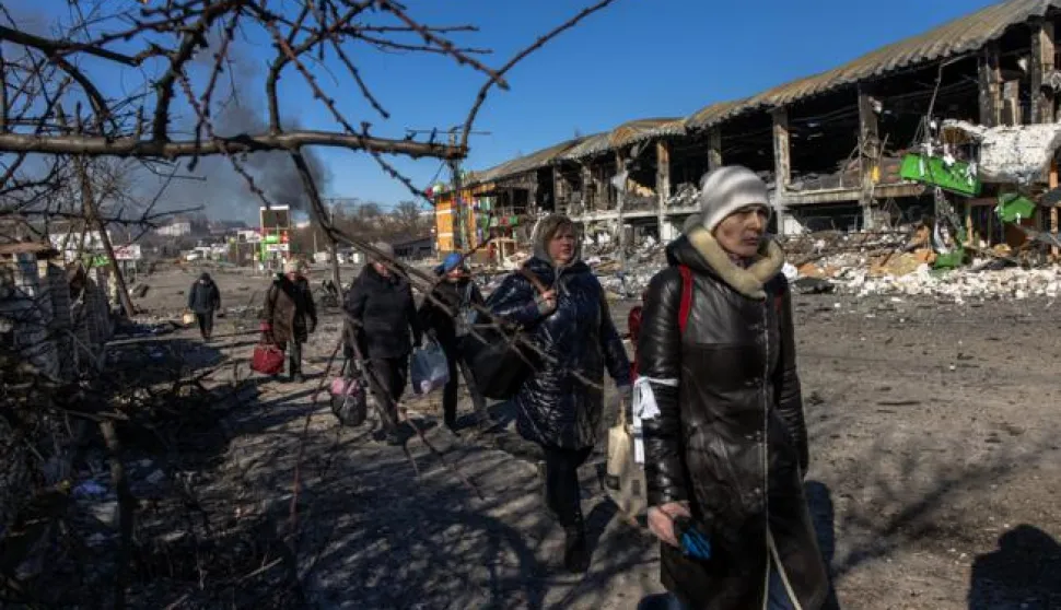 epa09814886 Residents coming from Bucha town, which is currently controlled by the Russian military, walk with luggage towards the Ukrainian checkpoint, at the frontline in Irpin town, Kyiv (Kiev) region, Ukraine, 10 March 2022. Thousands of residents are feeling Irpin and Bucha, as well as other settlements near Kyiv which were the most affected by the Russian army invasion. EPA/ROMAN PILIPEY