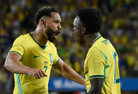 Brazil's forward #07 Matheus Cunha and Brazil's forward #10 Vinicius Junior celebrate their team's first goal during a friendly football match between Brazil and Croatia at Camping World Stadium in Orlando, Florida, on March 31, 2026. (Photo by MIGUEL J RODRIGUEZ CARRILLO/AFP)