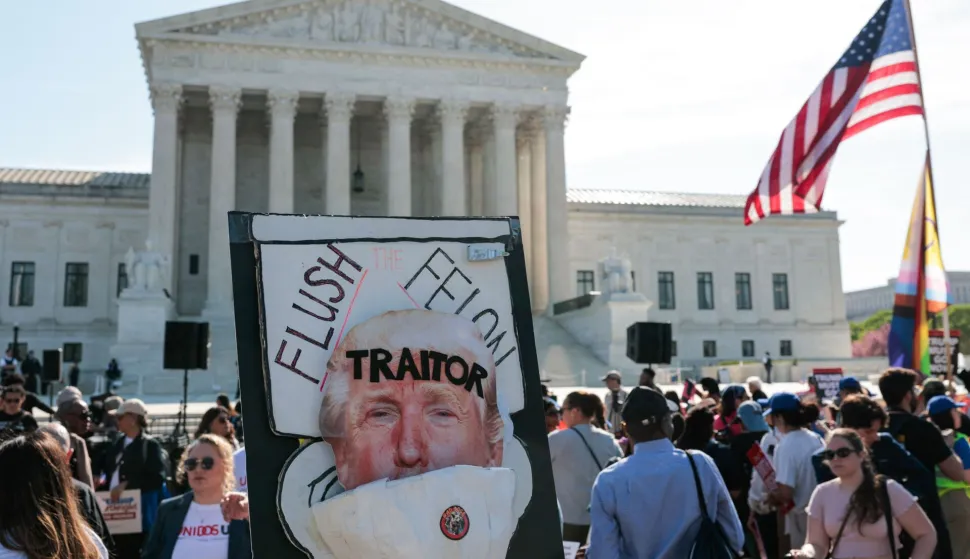 An anti-Trump sign is displayed as demonstrators rally outside the US Supreme Court as President Donald Trump attends oral arguments in Washington, DC on April 1, 2026. President Donald Trump is watching in person as the US Supreme Court hears a landmark case weighing the constitutionality of his contentious bid to end birthright citizenship, an extraordinary and possibly unprecedented move for the nation's highest office. (Photo by Kent Nishimura/AFP)