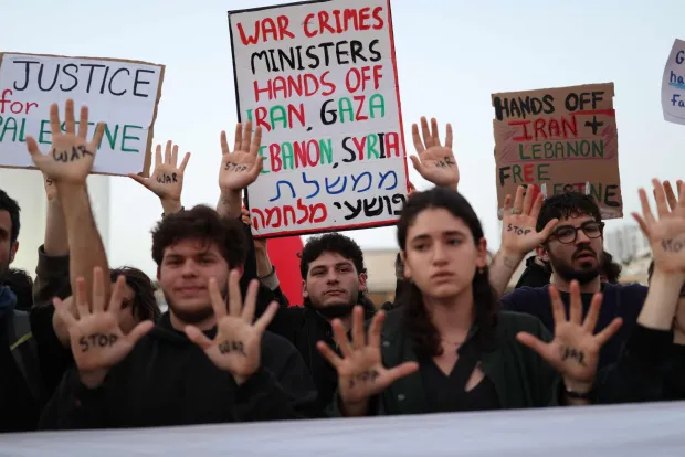 Israeli left-wing activists hold placards while taking part in a protest at HaBima Square in Tel Aviv on April 4, 2026, against the ongoing war with Iran. Carrying anti-war banners and chanting slogans against Prime Minister Benjamin Netanyahu, hundreds of Israelis rallied in Tel Aviv on March 4 to protest the war with Iran. Since February 28, the United States and Israel have conducted joint strikes against Iran, prompting the Islamic Republic to retaliate with daily missile barrages targeting Israel and several neighbouring countries across the region. (Photo by Ilia YEFIMOVICH/AFP)/