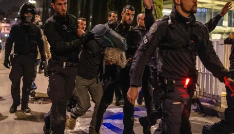 Israeli police arrest a demonstrator at HaBima Square in Tel Aviv on April 4, 2026, protesting against the ongoing war with Iran. Carrying anti-war banners and chanting slogans against Prime Minister Benjamin Netanyahu, hundreds of Israelis rallied in Tel Aviv on April 4 to protest the war with Iran. Since February 28, the United States and Israel have conducted joint strikes against Iran, prompting the Islamic Republic to retaliate with daily missile barrages targeting Israel and several neighbouring countries across the region. (Photo by Ilia YEFIMOVICH/AFP)/