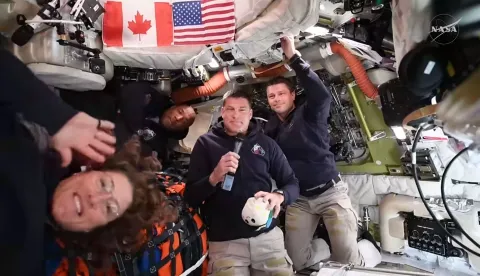 This screengrab from a NASA live broadcast video shows (L-R) NASA astronaut and Artemis II Mission Specialist Christina Koch, NASA astronaut and Artemis II pilot Victor Glover, Canadian Space Agency astronaut Artemis II Mission Specialist Jeremy Hansen and NASA astronaut and Artemis II Commander Reid Wiseman during a press call as they travel to the Moon in the Orion spacecraft, on April 3, 2026. The four Artemis astronauts have passed the halfway point between Earth and the Moon on the way to their planned lunar flyby, NASA said on Friday evening. "You are now closer to the moon than you are to us on Earth," mission control told the astronauts at around 11 pm (0400 GMT), according to the space agency's official live broadcast. (Photo by NASA/AFP)/RESTRICTED TO EDITORIAL USE - MANDATORY CREDIT "AFP PHOTO/NASA" - NO MARKETING NO ADVERTISING CAMPAIGNS - DISTRIBUTED AS A SERVICE TO CLIENTS