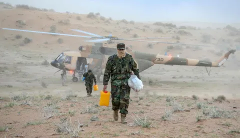TOPSHOT - Taliban security personnel carry food aid for distributing people stranded by floods in the Daman district of Kandahar province on April 5, 2026. Heavy rain and storms have killed at least 121 people over two weeks across Afghanistan and Pakistan, disaster officials in both countries said on April 4. (Photo by Sanaullah SEIAM/AFP)