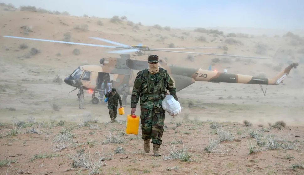 TOPSHOT - Taliban security personnel carry food aid for distributing people stranded by floods in the Daman district of Kandahar province on April 5, 2026. Heavy rain and storms have killed at least 121 people over two weeks across Afghanistan and Pakistan, disaster officials in both countries said on April 4. (Photo by Sanaullah SEIAM/AFP)