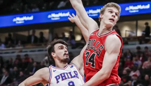 epa06397913 Chicago Bulls forward Lauri Markkanen of Finland (R) watches a shot taken by Philadelphia 76ers forward Dario Saric of Croatia in the first half of their NBA game at the United Center in Chicago, Illinois, USA, 18 December 2017. EPA/TANNEN MAURY------gn dva stupca color sport
