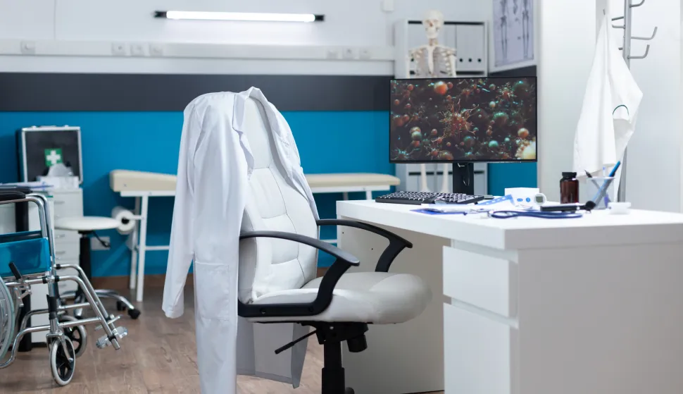 Computer with covid19 illustration on screen standing on desk in empty office room during global pandemic. Modern hospital room equipped with professional medical instruments. Virus cell imageobiteljska medicina ordinacija doktor liječnik freepik