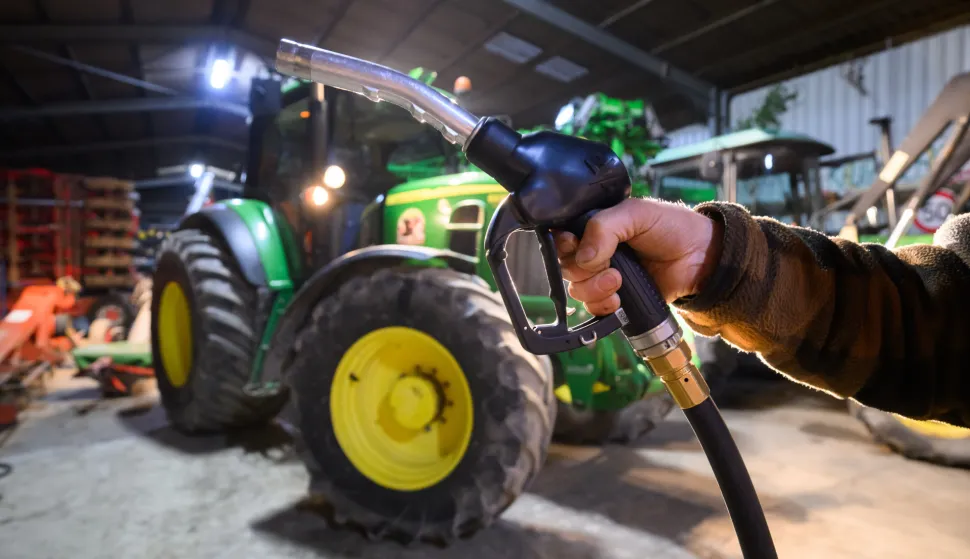 21 December 2023, Lower Saxony, Hanover: A farmer in the Hanover region holds a nozzle of his diesel tank in front of a tractor in his vehicle shed. Recently, thousands of farmers have been campaigning against the coalition government's plans to abolish agricultural diesel benefits and the vehicle tax exemption for agricultural vehicles. Agriculture Minister ?zdemir (Greens) is sticking to his rejection of these cost-cutting measures. Photo: Julian Stratenschulte/dpa Photo: Julian Stratenschulte/DPA