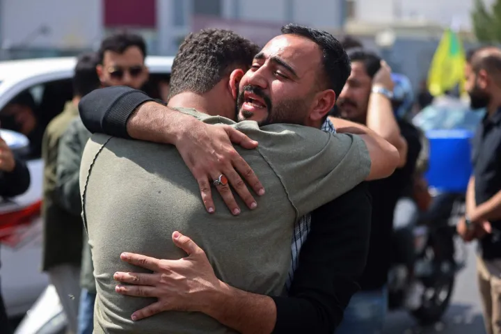 Mourners react before the mourning procession for a member of Iraq's pro-Iran paramilitary group Hezbollah Brigades (Kataeb Hezbollah) who was killed the previous day in a strike in Basra, during the funeral in Baghdad on April 8, 2026. Iraqi armed factions loyal to Iran and operating under the banner of the "Islamic Resistance in Iraq" announced a two-week halt to attacks they had launched since the start of the war in the Middle East against "enemy bases" in Iraq and the region. The announcement came shortly after Washington and Tehran declared a ceasefire for the same period. (Photo by AHMAD AL-RUBAYE/AFP)