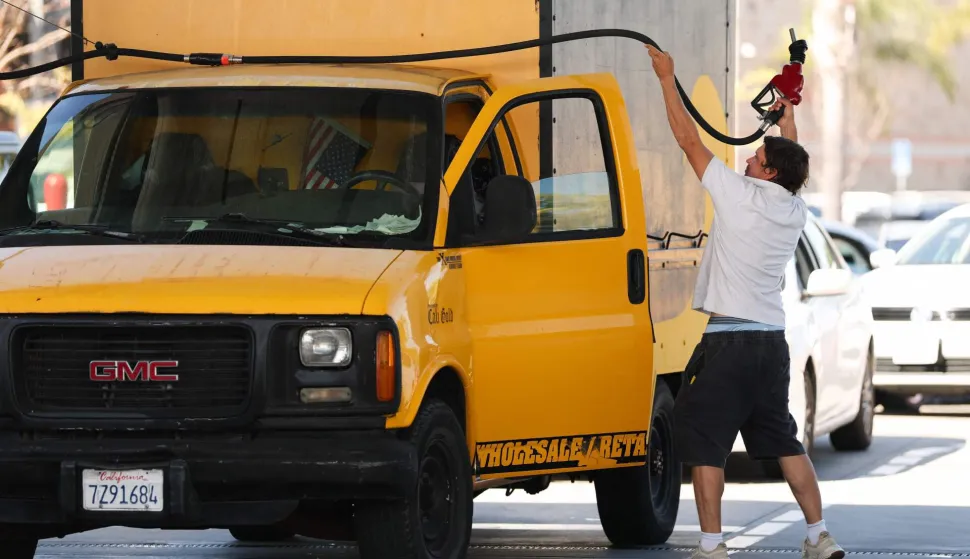 A driver pulls the gasoline pump hose to fill his truck tank at a gas station in the Marina Del Rey community of Los Angeles, California on March 2, 2026. Energy prices surged on March 2 as the war in the Middle East led to outages of key energy production operations. In parallel, energy markets are also absorbing a de facto halt to traffic in the Strait of Hormuz, through which about 20 percent of global supply of oil and liquid natural gas travel.The waterway has not technically been closed, but major maritime companies have suspended travel through it as insurance costs soar amid heightened risk. (Photo by Patrick T. Fallon/AFP)