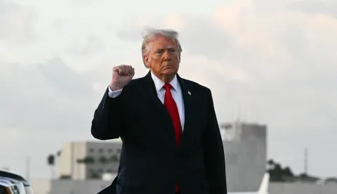 US President Donald Trump makes a fist upon arrival at Miami International Airport in Miami, on April 11, 2026. Trump is traveling to Florida to attend a UFC event and spend the weekend at his Mar-a-Lago residence. (Photo by Jim WATSON/AFP)