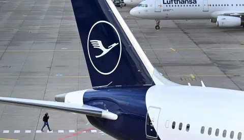 The logo of German airline Lufthansa is seen on an aircraft parked on the tarmac at the international Frankfurt Airport, Frankfurt am Main, western Germany, on March 12, 2026, as pilots for Lufthansa are on strike called by pilots' union Vereinigung Cockpit over a pensions dispute. The strike will affect Lufthansa Cargo and passenger flights "departing from German airports between 00:01 local time on March 12, 2026 and 23:59 local time on March 13, 2026", the union said. However, flights to several key Middle East destinations will be excluded from the industrial action "in light of the current situation" in the region, according to the statement. (Photo by Kirill KUDRYAVTSEV/AFP)