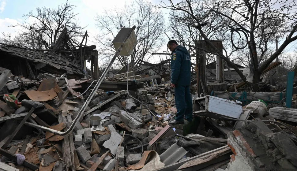 A Russian rescuer stands among the rubble of a destroyed house following an air attack in Yasynuvata, Russia-controlled Donetsk region of Ukraine on April 11, 2026, amid the Russian invasion of Ukraine. (Photo by AFP)