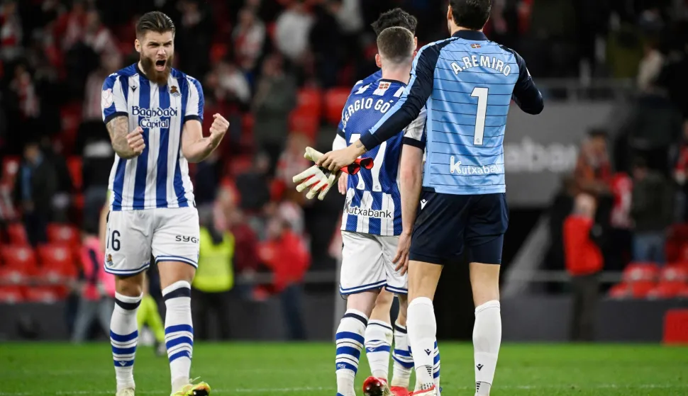 Real Sociedad's Croatian defender #16 Duje Caleta Car and Real Sociedad's Spanish goalkeeper #01 Alex Remiro celebrate at the end of the Spanish Copa del Rey (King's Cup) semi final first leg football match between Athletic Club Bilbao and Real Sociedad at San Mames Stadium in Bilbao on February 11, 2026. (Photo by ANDER GILLENEA/AFP)