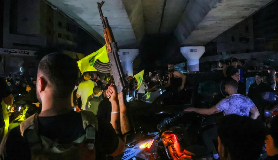 TOPSHOT - Supporters of Hezbollah celebrate the ceasefire with Israel as it takes effect, in the southern suburbs of Beirut, Lebanon, on April 17, 2026. Gunfire erupted in Beirut's southern suburbs as a ceasefire with Israel came into effect at midnight on April 17 (2100 GMT Thursday), according to AFP journalists and AFPTV footage. State media also reported "heavy gunfire" accompanying the start of the 10-day truce, announced earlier by US President Donald Trump. (Photo by ibrahim AMRO/AFP)/