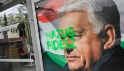 A tag reads 'Liar Fidesz' over a placard about a national petition against war, showing outgoing Hungarian Prime Minister and Fidesz leader Viktor Orban, at a bus stop near the South Railway Station in Budapest, Hungary on April 13, 2026, one day after general elections. Hungarian prime minister-elect Peter Magyar pledged on April 13 to usher in a "new era" after defeating nationalist leader Viktor Orban in elections seen as a blow to hard-right populism. (Photo by Ferenc ISZA/AFP)