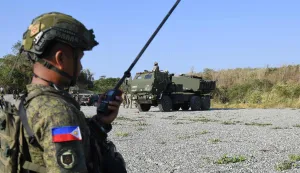 A Philippine soldier (L) stands in front of a US army High Mobility Artillery Rocket System (HIMARS)launcher (R) during a joint exercise between the Philippines and the US at Fort Magsaysay, in the Philippines' Nueva Ecija province north of Manila on April 16, 2026. (Photo by Ted ALJIBE/AFP)