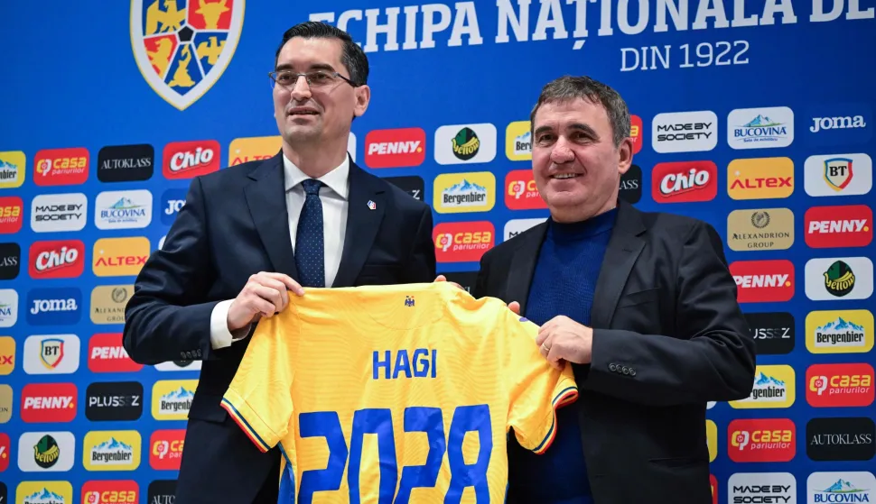 Romanian Football Federation president Razvan Burleanu (L) and the newly appointed head coach of Romania's national football team Gheorghe Hagi pose with a jersey during a press conference in Bucharest on April 20, 2026. Hagi signed a four-year contract to return to the helm of the national team. The 61-year-old legend, nicknamed "The King" and "Maradona of the Carpathians," succeeded the late Mircea Lucescu with ambitious goals to win the Nations League and qualify for the European Championships. (Photo by Daniel MIHAILESCU/AFP)