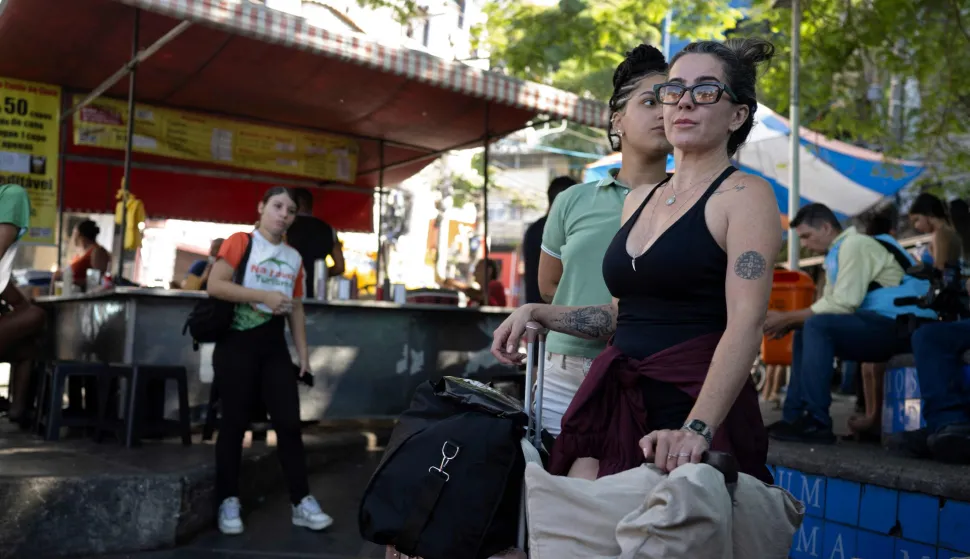 Tourists wait for transportation to leave the Vidigal favela after a police operation in Rio de Janeiro, Brazil on April 20, 2026. A police operation against drug trafficking took place in the Vidigal favela early morning in the touristy south zone of Rio de Janeiro, during which around 200 tourists were temporarily stranded on Morro Dois Irmaos, from where they were later evacuated unharmed by local tour guides. (Photo by Pablo PORCIUNCULA/AFP)