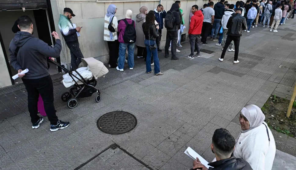 People wait in a long queue to enter the Consulate General of the Kingdom of Morocco in Bilbao, Spain, on April 15, 2026. Spain's left-wing government yesterday approved a decree expected to regularise around 500,000 undocumented migrants, said Prime Minister Pedro Sanchez, who has bucked a European trend cracking down on irregular immigration. (Photo by ANDER GILLENEA/AFP)