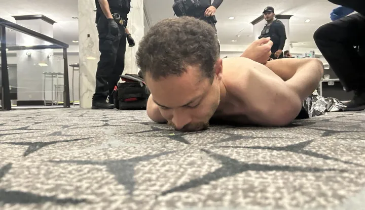 TOPSHOT - This image released by US President Donald Trump via his Truth Social account (@realDonaldTrump) shows a person he claims to be the alleged suspect in the shooting incident at the White House Correspondents? Dinner on the ground after being apprehended on April 25, 2026. US Secret Service agents bundled Donald Trump from the stage as shots rang out Saturday evening at a media gala, in what the president later described as an attack by a "would-be assassin." Armed guards opened fire at the gunman who charged through security screening just outside the ballroom of the hotel, where Trump, First Lady Melania Trump, many senior government officials and hundreds of other black-tie guests had gathered. (Photo by @REALDONALDTRUMP/TRUTH SOCIAL/AFP)/RESTRICTED TO EDITORIAL USE - MANDATORY CREDIT "AFP PHOTO/@REALDONALDTRUMP - TRUTH SOCIAL " - HANDOUT - NO MARKETING NO ADVERTISING CAMPAIGNS - DISTRIBUTED AS A SERVICE TO CLIENTS