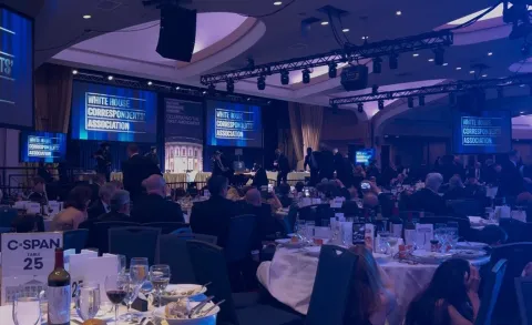 TOPSHOT - A screen grab taken from a video filmed by an AFP reporter shows armed agents moving to the stage after loud bangs were heard during the White House Correspondents' dinner at the Washington Hilton in Washington, DC, on April 25, 2026. Shots were fired as US President Donald Trump attended a press dinner in Washington on Saturday night, witnesses and AFP reporters confirmed. Loud bangs were heard and guests at the black-tie White House Correspondents' Dinner scrambled to hide under tables. (Photo by Danny KEMP and AFPTV teams/AFP)