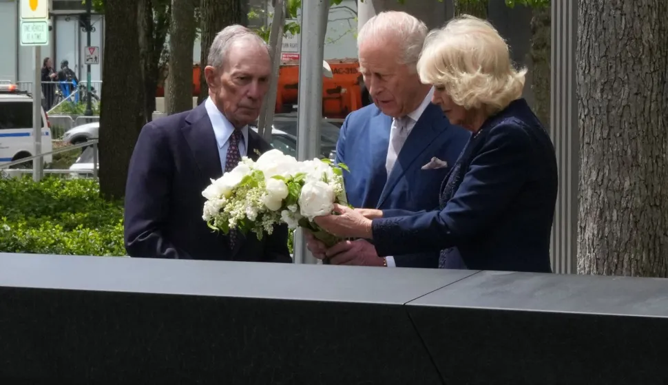 Britain's King Charles III and Queen Camilla place flowers as they visit the 9/11 Memorial alongside former New York mayor Michael Bloomberg in New York on April 29, 2026. (Photo by TIMOTHY A. CLARY/AFP)