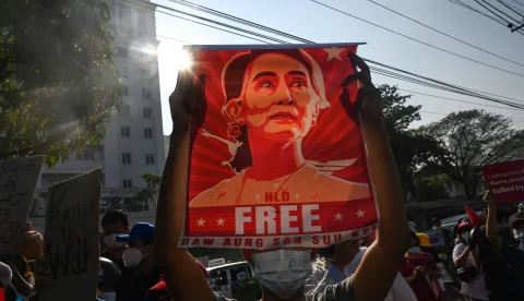 (FILES) A protester holds up a poster featuring Aung San Suu Kyi during a demonstration against the military coup in front of the Central Bank of Myanmar in Yangon on February 15, 2021. Myanmar's coup-ousted and detained democratic leader Aung San Suu Kyi had her sentence reduced as part of a mass amnesty on April 17, 2026, a source close to her legal case told AFP. (Photo by AFP)