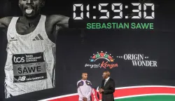 Kenya's President William Ruto (R) congratulates Kenyan marathon runner Sebastian Sawe (L) on stage during a ceremony at State House in Nairobi, on April 30, 2026, after breaking a historic world record at the London Marathon. Sebastian Sawe became the first man to run under two hours for a marathon in race conditions thanks to extraordinary talent, a punishing training regime, and the lightest shoes in history. In London on April 26, 2026, the 31-year-old Kenyan achieved one of sport's milestones, ranking alongside Roger Bannister's first sub-four minute mile in 1954. (Photo by Luis TATO/AFP)