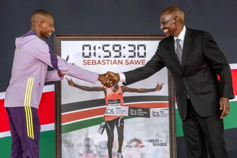 Kenya's President William Ruto (R) shakes hands as he congratulates Kenyan marathon runner Sebastian Sawe (L) during a ceremony at State House in Nairobi, on April 30, 2026, after breaking a historic world record at the London Marathon. Sebastian Sawe became the first man to run under two hours for a marathon in race conditions thanks to extraordinary talent, a punishing training regime, and the lightest shoes in history. In London on April 26, 2026, the 31-year-old Kenyan achieved one of sport's milestones, ranking alongside Roger Bannister's first sub-four minute mile in 1954. (Photo by Luis TATO/AFP)