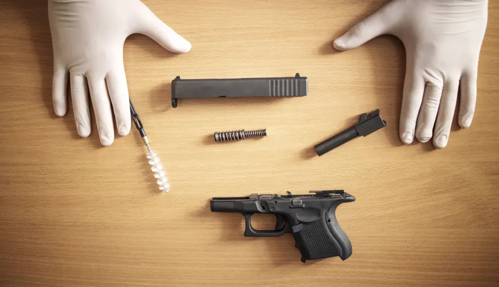 Firearm cleaning and maintenance after use at shooting range.pi&scaron;tolj ilustracijafreepik